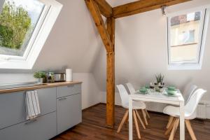 cocina y comedor con mesa blanca y sillas en CASSEL LOFTS - Kleines Loft nähe Uni & Klinikum, en Kassel