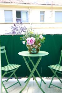 a vase of flowers on a table with two chairs at L'échelle Rouge in Cannes