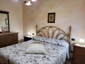 モンティチャーノにあるVilla Il Fontaninoのベッドルーム1室(ベッド1台、ナイトスタンド2台、鏡付)