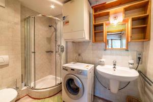 uma casa de banho com um lavatório e uma máquina de lavar roupa em Tabià La Stua em Arabba