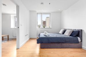 a bedroom with a bed in a white room at London's Charm 2 BR Flat CB3 in Croydon