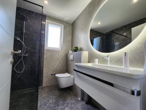 a bathroom with a sink and a shower and a mirror at New Apartment White Angel in Duće +18 photos