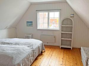 a bedroom with a bed and a window at Holiday home Svaneke LVI in Svaneke