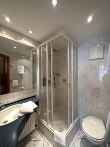 La salle de bains est pourvue d'une douche, de toilettes et d'une baignoire. dans l'établissement Landhotel Vessens Hoff, à Buchholz in der Nordheide