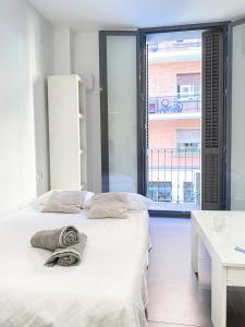 a bedroom with two beds and a large window at Alojamiento Vilardell in Barcelona