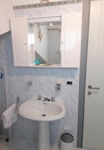 y baño con lavabo blanco y espejo. en B&B Al Verde & Mare, en Porto Garibaldi