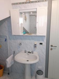 y baño con lavabo blanco y espejo. en B&B Al Verde & Mare, en Porto Garibaldi