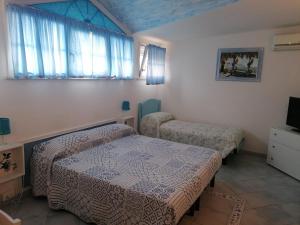 Habitación con 2 camas, TV y ventanas. en B&B Al Verde & Mare, en Porto Garibaldi