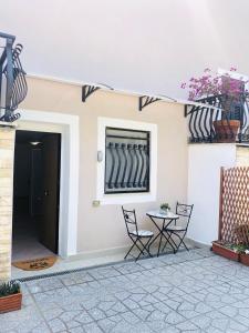 patio con mesa, sillas y ventana en Casa di GiAde en Anguillara Sabazia