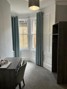 una sala da pranzo con tavolo, sedie e una finestra di Arrandale Guest House a Edimburgo