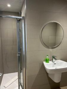 a bathroom with a sink and a shower with a mirror at Arrandale Guest House in Edinburgh