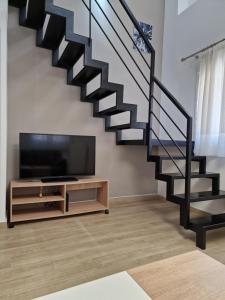 a living room with a staircase and a flat screen tv at SKG City Loft in Thessaloniki