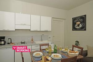 a kitchen with white cabinets and a table with food at Villa Caterina Apartments by Wonderful Italy in Desenzano del Garda