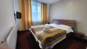 een hotelkamer met een bed met schoenen erop bij Boutique Global in Braşov