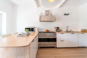 een keuken met witte kasten en een fornuis met oven bij La maison d'à côté in Carpentras