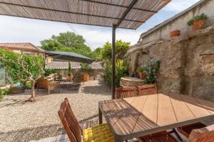 een patio met een tafel en stoelen en een parasol bij La maison d'à côté in Carpentras