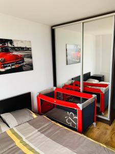 a bedroom with two beds and a red car on the wall at Apartament na Orchidei in Bielsko-Biała