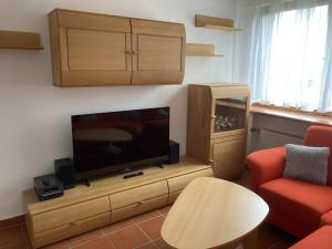 a living room with a flat screen tv on a wooden entertainment center at Oreste in Overath