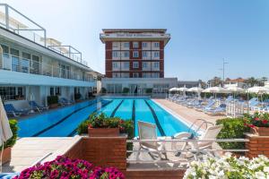 a swimming pool with chairs and a hotel at Grand Hotel & Riviera in Lido di Camaiore