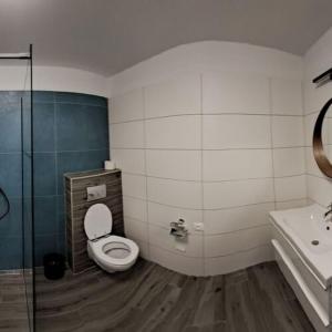 a bathroom with a toilet and a sink and a shower at R&R Vendégház Vonyarcvashegy in Vonyarcvashegy