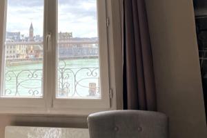 a room with a window with a view of a city at VUE PORT "Le Studio du Bout du Quai" 2pers Dieppe in Dieppe +39 photos