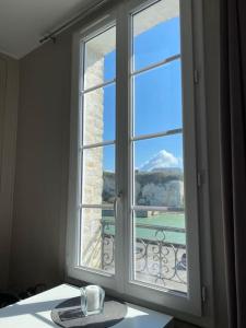 a window with a cup on a table in front of it at VUE PORT "Le Studio du Bout du Quai" 2pers Dieppe in Dieppe