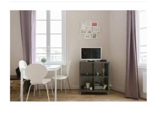 a dining room with a table and chairs and a television at VUE PORT "Le Studio du Bout du Quai" 2pers Dieppe in Dieppe