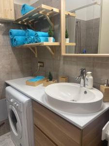 a bathroom with a sink and a washing machine at A Casa Letizia San Salvo Marina in Marina di Montenero