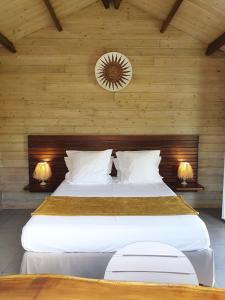 a bedroom with a large bed with wooden walls at Les Coeurs d'Amants in Saint-Joseph
