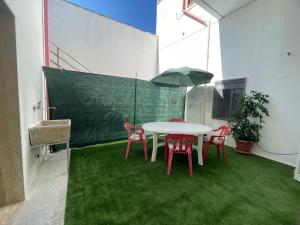 eine Terrasse mit einem Tisch, Stühlen und einem Sonnenschirm in der Unterkunft Casa via del mare in Veglie