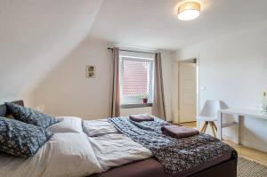 1 dormitorio con cama, mesa y ventana en Landhausappartment, en Bermatingen