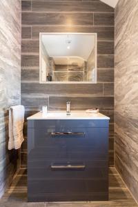 een badkamer met een blauwe wastafel en een spiegel bij Bective Stud Apartments in Navan