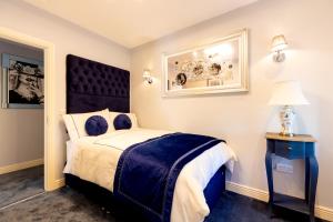 a bedroom with a bed with a blue and white comforter at Bective Stud Apartments in Navan