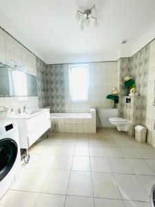 ein Badezimmer mit einer Badewanne, einem WC und einem Waschbecken in der Unterkunft Rooms4Rent Cottage in Klaipėda