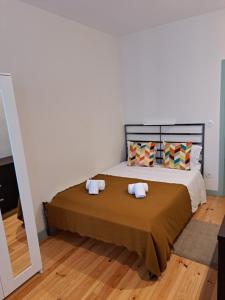 een slaapkamer met een groot bed met 2 kussens bij Near River 63 in Vila Nova de Gaia