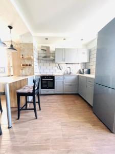 a kitchen with white cabinets and a wooden table at Rooms4Rent Cottage in Klaipėda