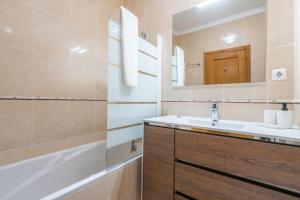 a bathroom with a sink and a mirror and a tub at The Sunset 1 Bed Flat short walk Armação beach in Armação de Pêra +14 photos