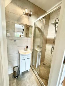 a bathroom with a shower and a sink and a mirror at Domki i pokoje Linda Zator in Zator