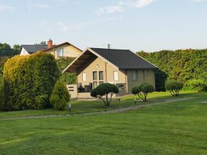 a house with a green lawn and trees at Domki i pokoje Linda Zator in Zator