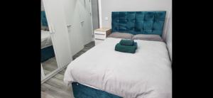 a bedroom with a large bed with a blue headboard at Ground Floor 1 Bed Flat Dartford- 1 - Fully Equipped - Fibre Wifi in Dartford