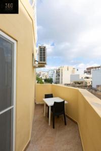 een balkon met een tafel en stoelen in een gebouw bij Beautiful, central home with all amenities & WIFI by 360 Estates in Tal-Pietà
