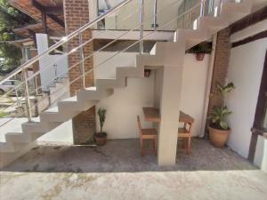 a staircase with a table and a desk under it at Chalé Brisa do Mar in Santa Cruz Cabrália