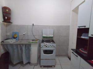a small kitchen with a stove and a table at Chalé Brisa do Mar in Santa Cruz Cabrália