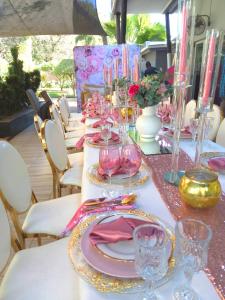 una mesa con placas rosas y doradas y gafas. en Ecolux Boutique Hotel en Komatipoort