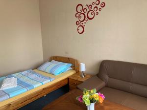 - une petite chambre avec un lit et un canapé dans l'établissement Hotel Restaurant Am Worns Berg, à Broock