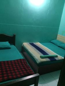 two twin beds in a room with at faTuur Inn in Male City