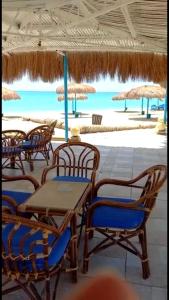 einen Tisch und Stühle am Strand mit Meerblick in der Unterkunft شاليه فندقي ڤيو البحر Ain sokhna-families& married only in Ain Suchna