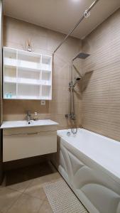 a bathroom with a sink and a bath tub at Dona Tbilisi in Tbilisi City +4 photos