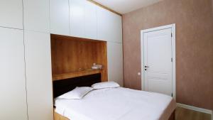 a bedroom with a white bed and a white closet at Dona Tbilisi in Tbilisi City