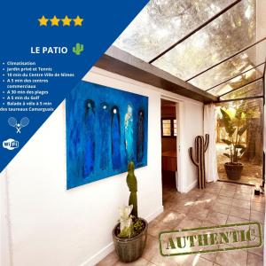 une affiche d'une maison avec une peinture sur le mur dans l'établissement Le patio, jardin privatif, tennis, à Nîmes